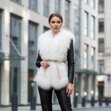 Įkelti nuotrauką į galerijos peržiūros programą, Woman wearing a white fur vest over a black leather outfit in an urban setting.
