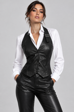 Įkelti nuotrauką į galerijos peržiūros programą, A woman modeling a black faux-leather vest and matching black faux-leather pants over a white button-down shirt, photographed against a solid light gray studio background.