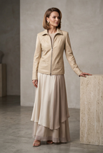 Load image into Gallery viewer, A beige faux-leather jacket with a stand collar and front zipper, displayed on a black mannequin torso against a light gray background.