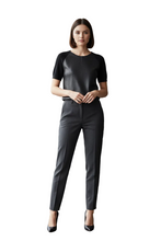 Load image into Gallery viewer, A woman modeling a short-sleeve black top with textured raglan sleeves and dark gray slim-fit trousers, paired with black high heels, against a plain white background.