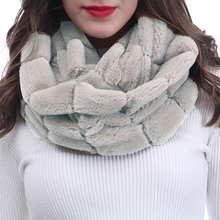 Įkelti nuotrauką į galerijos peržiūros programą, A woman with long brown hair wearing a chunky, textured faux-fur infinity scarf in a light sage green color, paired with a white ribbed knit top against a plain white background.