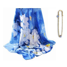 Load image into Gallery viewer, A blue silk scarf with a floral pattern and a golden-colored brooch, displayed alongside the brooch.
