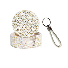 Load image into Gallery viewer, A set of round patent leather coasters with a geometric pattern, including a key holder with a wrist strap.