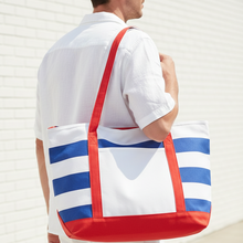 Load image into Gallery viewer, Person wearing a red, white, and blue striped tote bag against a light background