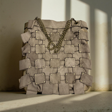 Load image into Gallery viewer, Gray woven handbag with gold chain on a neutral background