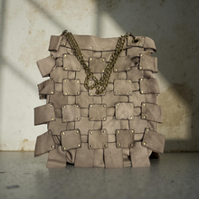 Load image into Gallery viewer, Brown woven handbag with gold chain on a textured surface