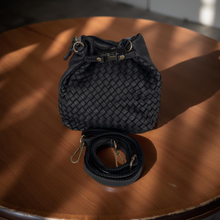 Load image into Gallery viewer, Black woven bag with a strap on a wooden surface