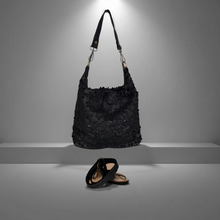 Load image into Gallery viewer, Black textured handbag and shoes on a gray platform with a gray background