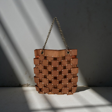 Load image into Gallery viewer, Brown woven handbag with chain handle on a textured surface