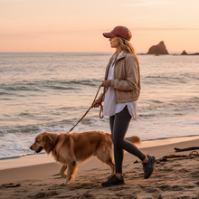 Įkelti nuotrauką į galerijos peržiūros programą, Woman walking a dog on a beach at sunset