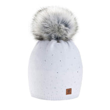 Load image into Gallery viewer, A white knitted cap with a grey artificial fur pom-pom and Swarovski crystals, featuring a small brown label with a brand logo.