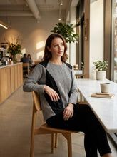 Load image into Gallery viewer, Woman sitting at a table in a modern cafe