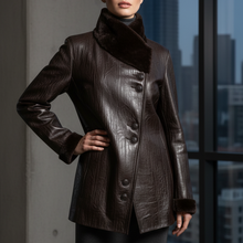 Įkelti nuotrauką į galerijos peržiūros programą, A woman wearing a dark brown textured leather coat with a high dark brown fur collar, standing in front of a window with a city view.