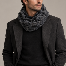 Įkelti nuotrauką į galerijos peržiūros programą, A man wearing a dark gray textured knit infinity scarf, a black sweater, and a charcoal gray blazer, standing against a solid light gray background.