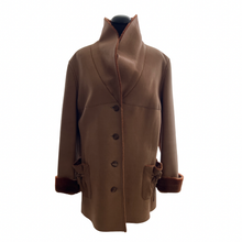 Load image into Gallery viewer, A camel brown Nappa Toscana sheepskin midi-length coat with a shawl collar, buttons down the front, and pockets on the front. It displays a loose silhouette and sheepskin lining visible at the neck and cuffs.