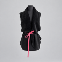 Load image into Gallery viewer, A black suede merino sheepskin loose fit vest with a pink tie on a mannequin.