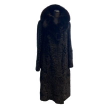 Load image into Gallery viewer, Black long astrakhan fur coat with fox fur collar, with hidden pockets in front and decorative leather details at then end.