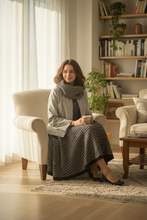 Load image into Gallery viewer, Woman sitting in a cozy living room holding a mug.