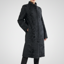 Įkelti nuotrauką į galerijos peržiūros programą, A model stands against a light gray studio background wearing a long black textured coat with a high stand collar, black pants, and black heeled ankle boots.