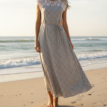 Load image into Gallery viewer, Woman in a dress standing on a beach with ocean waves in the background