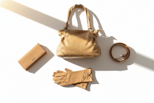Load image into Gallery viewer, Gold handbag, wallet, gloves, and ring on a white surface with soft shadows