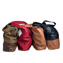 Load image into Gallery viewer, A collection of three leather handbags in red, brown, and black colors, displayed with their handles up.