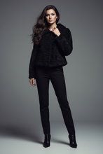Įkelti nuotrauką į galerijos peržiūros programą, A model stands against a dark gray studio background wearing a black textured cropped jacket, black slim-fit pants, and black ankle boots.