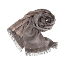 Load image into Gallery viewer, A grey and white striped textile scarf with fringes displayed on a neutral background.