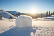 Load image into Gallery viewer, white fur cap on a snowy landscape with mountains and trees in the background