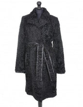 Load image into Gallery viewer, Black astrakhan knee-length coat with a tie, featuring a regular collar, pockets at the front, and fur hooks fastening. The coat is lined and has deep vents at the back.
