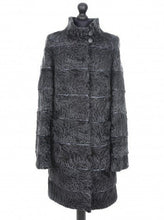 Load image into Gallery viewer, Dark grey astrakhan knee-length coat with decorative textile inserts, stand collar, front pockets, and fur hooks fastening. It is displayed on a mannequin with a visible label.