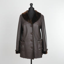 Įkelti nuotrauką į galerijos peržiūros programą, A dark brown Nappa sheepskin fur long jacket with a fur lining, featuring a regular collar, front pockets, and button fastening.
