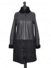 Load image into Gallery viewer, Black knee-length Nappa merino sheepskin fur coat with astrakhan fur (karakul) decoration, fitted silhouette press-studs fastening, and adjustable sleeves. The coat is displayed on a mannequin with a visible label.