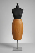 Įkelti nuotrauką į galerijos peržiūros programą, Camel color, midi-length, sheep leather skirt with a fitted silhouette, invisible zipper and vent at the back, displayed on a black mannequin.