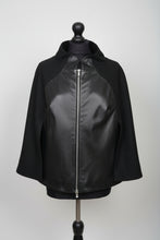 Load image into Gallery viewer, Black textile cloak with sheep leather details and a two-way zip fastening, displayed on a mannequin.