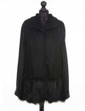 Load image into Gallery viewer, A black wool cloak with fox trimming on the pockets, featuring a classic cape shape with press-stud fastening, displayed on a mannequin with a tan hat and a light-colored shirt.