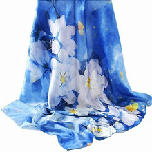 Load image into Gallery viewer, A blue silk scarf with a floral pattern displayed on a white background.