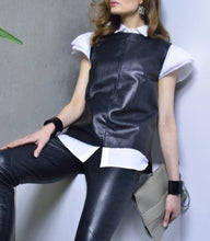 Load image into Gallery viewer, Black sleeveless leather blouse with round neckline and laser perforated leather in front, red lining, displayed on a woman with leather leggings and stylish outfit.