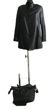 Load image into Gallery viewer, Black leather raincoat on a mannequin with a black bag below on a white background