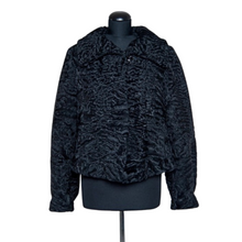 Load image into Gallery viewer, Black astrakhan fur short jacket displayed on a mannequin with fur hooks fastening and a slightly fitted silhouette.