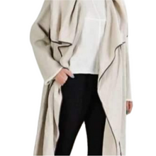 Load image into Gallery viewer, A long beige linen cardigan with a loose fit, displayed on a model who is showing the front and back of the garment.
