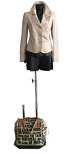 Load image into Gallery viewer, Mannequin wearing a beige blazer and black shorts with a patterned bag on a white background