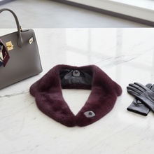 Įkelti nuotrauką į galerijos peržiūros programą, A dark burgundy faux fur cowl neck warmer with a snap closure, displayed on a white marble surface next to a gray handbag and black leather gloves.
