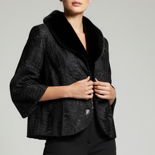 Įkelti nuotrauką į galerijos peržiūros programą, A model stands against a light gray studio background wearing a black textured cropped jacket with a black faux-fur collar, black trousers, and black heeled ankle boots.
