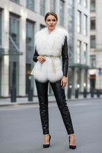 Įkelti nuotrauką į galerijos peržiūros programą, Woman wearing a white fur vest over a black leather outfit on a city street.
