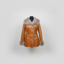 Load image into Gallery viewer, A tan leather coat with a light gray fur collar, cuffs, and hem, displayed on a black mannequin torso against a light gray background.

