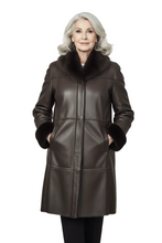 Load image into Gallery viewer, An older woman with silver-gray hair wearing a dark brown faux-leather coat with a black fur collar and matching fur-trimmed cuffs, standing against a light gray studio background.
