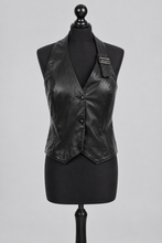 Įkelti nuotrauką į galerijos peržiūros programą, A black faux-leather vest with a shawl collar and button-front closure, displayed on a black dress form mannequin against a light gray studio background.
