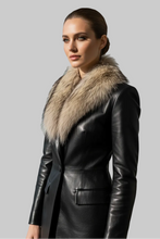 Įkelti nuotrauką į galerijos peržiūros programą, A woman wearing a black leather coat with a large beige fur collar, photographed against a plain light gray studio background.
