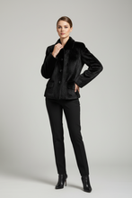 Įkelti nuotrauką į galerijos peržiūros programą, A model wearing a black textured faux-fur jacket with a dark collar, black trousers, and black high-heeled ankle boots, standing against a light gray studio background.
